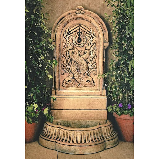A concrete wall fountain with fish design.