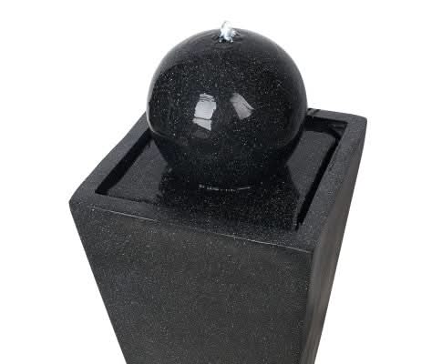A black solar water feature closeup view of water flow.