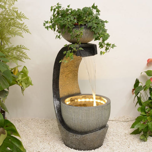 A bowl water feature with planter pot on top.