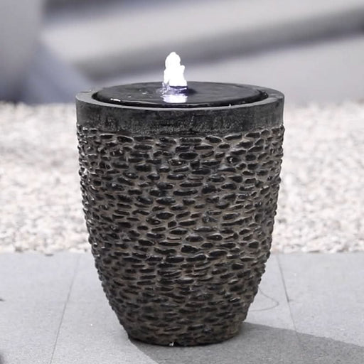 A bowl type of water feature with rock pebbles.