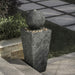 A tower & ball water feature near steps in an outdoor area.