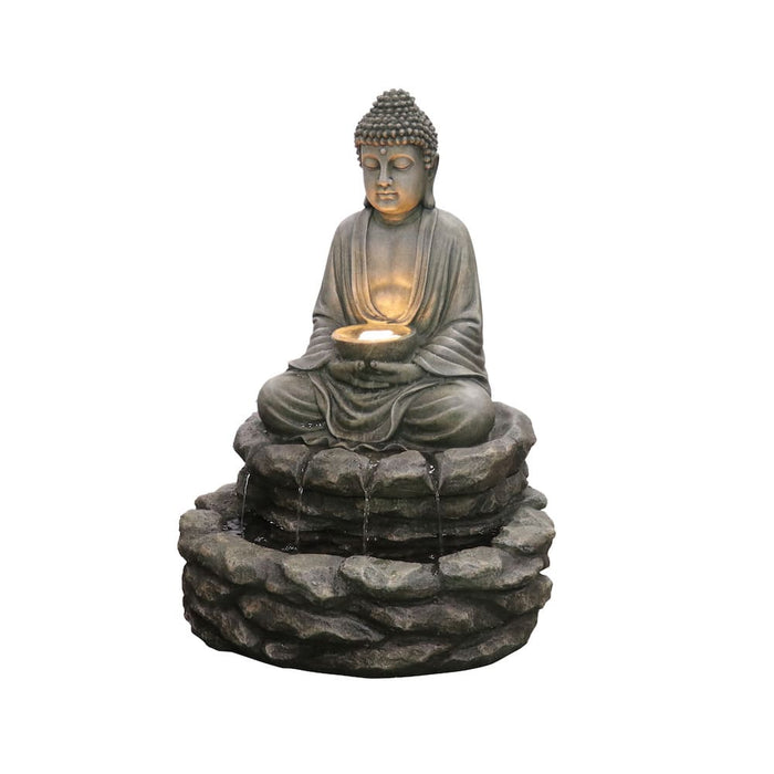 A water fountain with a Buddha sitting on top of rocks.