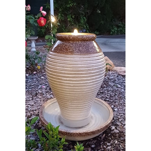 Ceramic urn water feature with LED light at dusk.