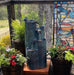 A dandelion themed water feature near pot plants.