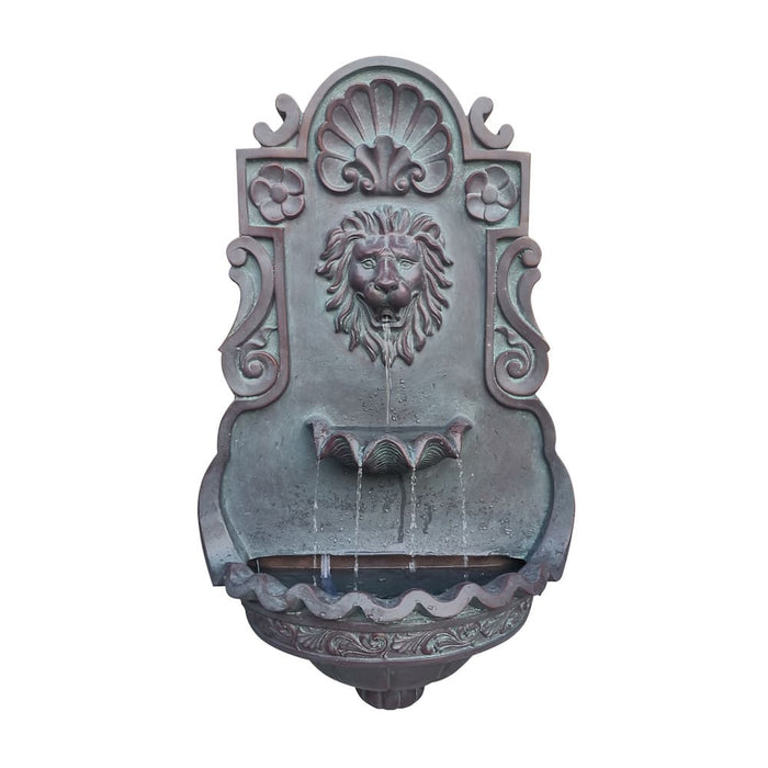 A bronze wall fountain with water pouring from a lion's head.
