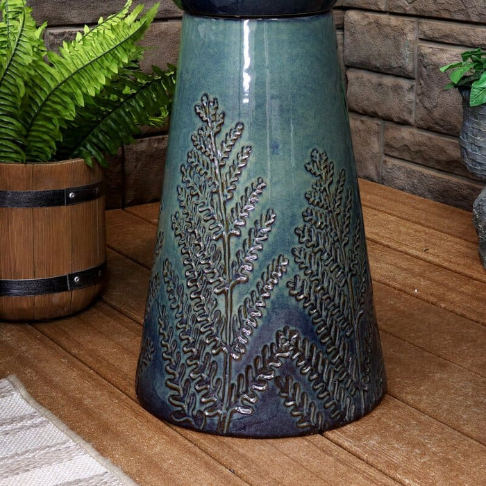 Close up view of the etched leaves of a bird bath fountain.