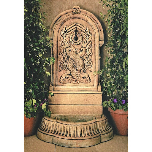 A concrete wall fountain with fish design.