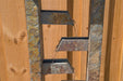 Close-up of slate water fountain with tiered spouts cascading water against a wooden fence backdrop.