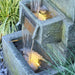A closeup view of a wall fountain's square bowls.