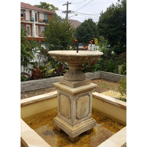 A large birdbath fountain in rust.