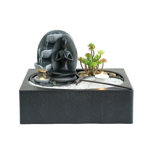 A tabletop fountain depicting a woman in meditation.