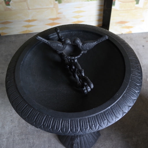 A bird bath bowl made from cast iron.